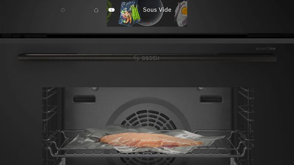 
       En vakuumpakket laks er placeret på risten i ovnen. På betjeningspanelet vises programmet „sous-vide“.
      