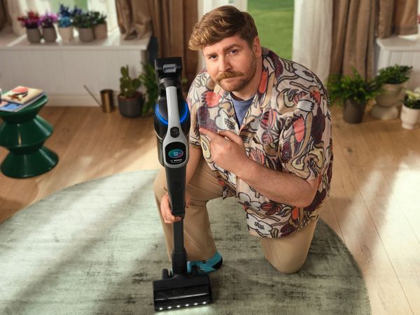 Person kneeling next to Unlimited 10 vacuum cleaner