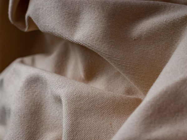 Dettaglio ravvicinato di un tessuto di lino beige con pieghe morbide