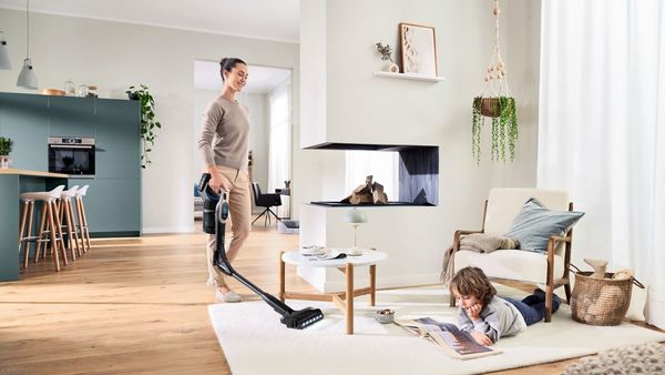 Person using flex tube element to vacuum area of living room