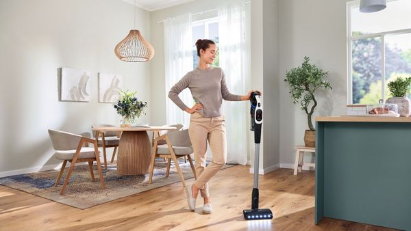 Person stood next to vacuum cleaner in living area