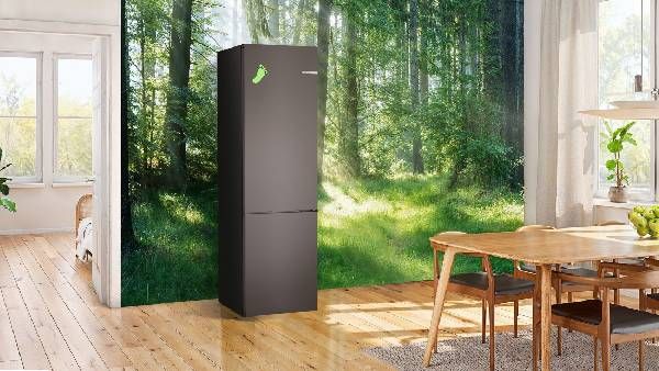 Frigorifero Green Collection di Bosch in una stanza con una carta da parati ambientata in un bosco