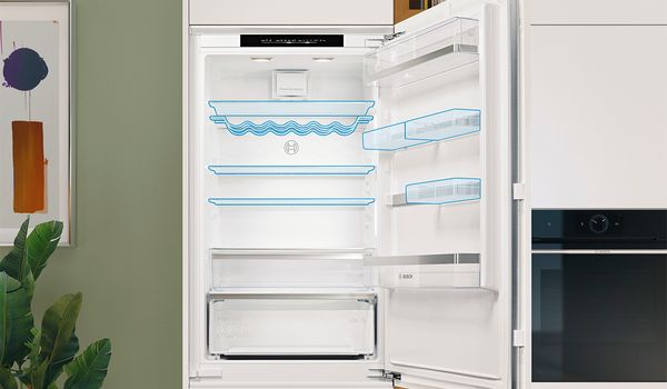 Un r&eacute;frig&eacute;rateur ouvert mettant en valeur des &eacute;tag&egrave;res transparentes et un tiroir, avec des contours bleus.