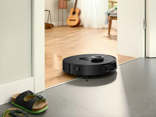 robot sprzatajcy w korytarzu, obok gitara i kapcie