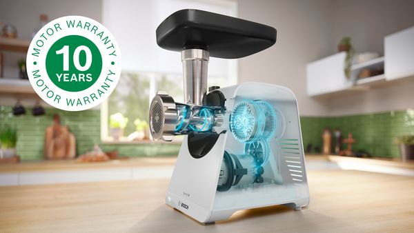 Valkoinen lihamylly keitti&ouml;n ty&ouml;tasolla ja vieress&auml; 10 vuoden moottoritakuun merkki.