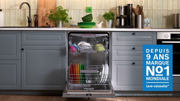 Lave-vaisselle ouvert dans une cuisine grise, label "Marque N°1 mondiale depuis 9 ans".