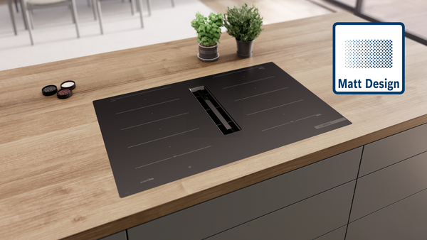 Matt Design Induktionskochfeld harmonisch eingebettet in helle Holzarbeitsplatte.
