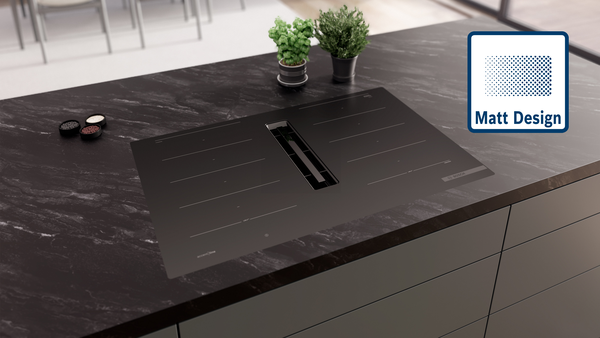 Modernes Induktionskochfeld im Matt Design, flächenbündig integriert in eine Arbeitsplatte aus Beton.