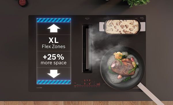 Moderne inductiekookplaat met XL Flex Zones, pan met vlees en groenten, en schaal met gebakken champignons.