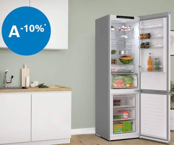 Een moderne koelkast met een transparante deur, waarin de etenswaren overzichtelijk zijn opgeborgen. De koelkast heeft strakke witte kastjes en een houten aanrechtblad.