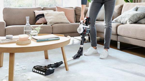 Person using Bosch Vacuum Cleaner flexibly under table