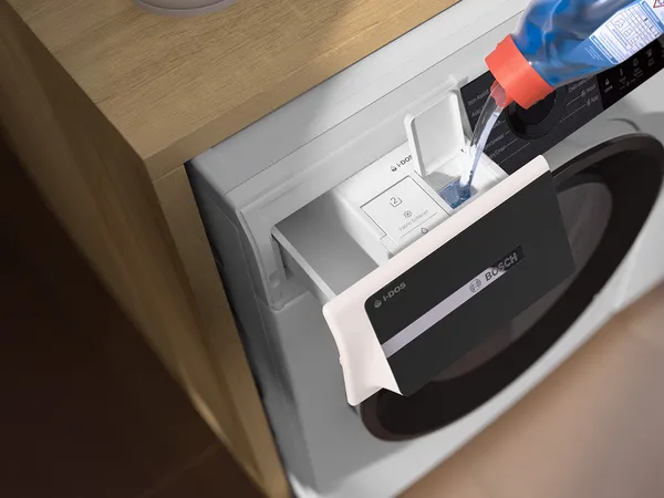 Primo piano del cassetto del detersivo di una lavatrice Bosch, che mostra un design elegante con una pianta in primo piano per un tocco moderno.