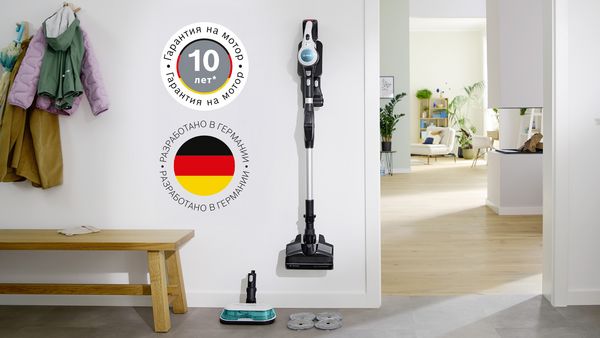 Bosch Unlimited 7 ProHygienic Aqua, опирающийся на стул с помощью умного парковочного зажима. Рядом с ним надпись «Мотор произведён в Германии» и логотип 10-летней гарантии на двигатель.
