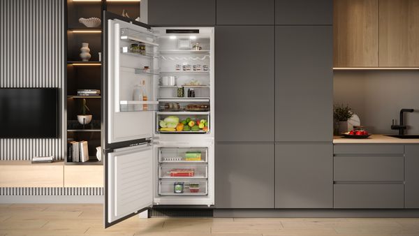 Prikaz ugradbenog frižidera s otvorenim vratima u modernoj kuhinji.