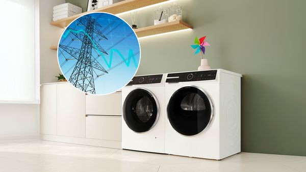 Een wasmachine en droogkast staan naast elkaar, met in een cirkel daarnaast een afbeelding die de dalende energieprijs weergeeft. 