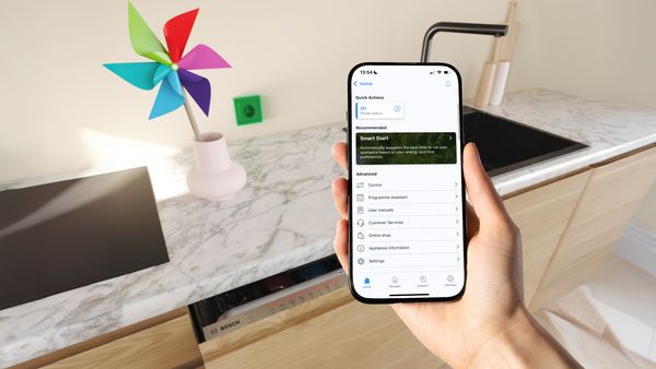 Een vaatwasser met een smartphone die Smart Start toont in de Bosch app.