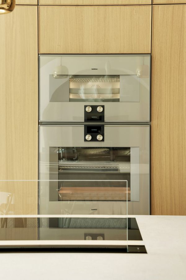 View across the kitchen island fitted with a Gaggenau flex induction cooktop, 200 series table ventilation and 400 series ovens.