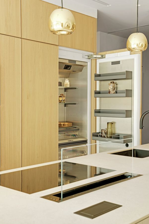 View across the kitchen island fitted with a Gaggenau flex induction cooktop, 200 series table ventilation and 400 series refrigerator