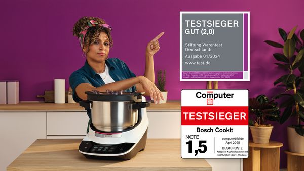 Eine Frau steht neben einem Cookit und präsentiert dessen Testerfolge.