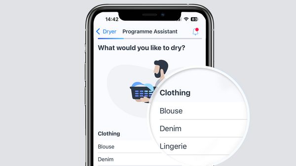 Ein Smartphone auf einer grauen Oberfläche zeigt den Programmassistenten, der in der Bosch Home Connect App geöffnet ist. 