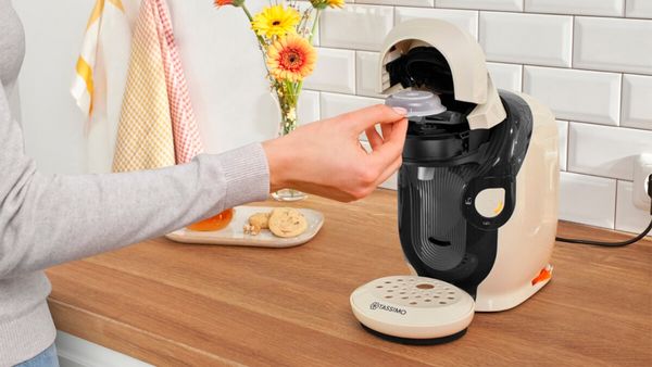 Person putting pod in Tassimo machine