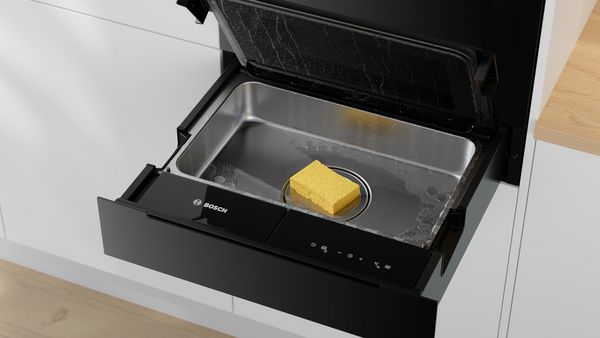       Eine Bosch-Küchenschublade mit einem gelben Schwamm darin.     