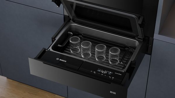 In einem Bosch Dampfgarer stehen vier klare Glasbehälter, die mit Dampf desinfiziert wurden.