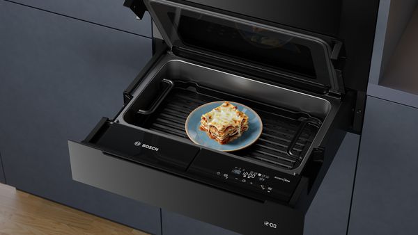 Ein Bosch accent line Dampfgarer in dem ein Teller Lasagne steht.