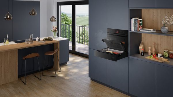 Модерна кухня с вградена фурна Bosch, дървен под и големи прозорци с изглед към балкон.