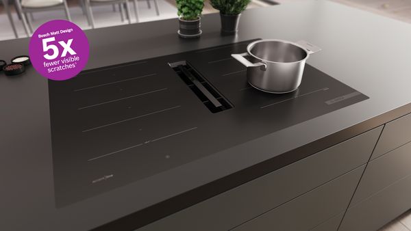 Vlakinbouw kookplaat met matte, koolzwarte afwerking, ingebouwd in een zwart werkblad.