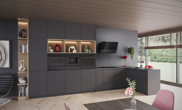 
       Breed zijaanzicht van L-vormige keuken met Bosch Matt Design productlijn en 3-delige ovencombinatie.
      