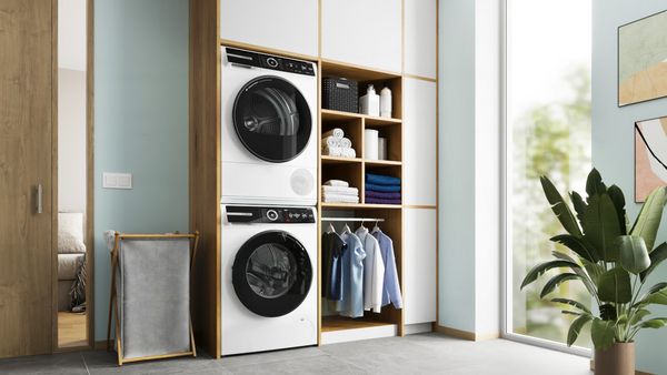 Smartphone med Bosch Home Connect-appen, der styrer vaskemaskinen og tørretumbleren.