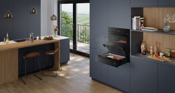 Moderne Küche mit dunklen Schränken und einem eleganten accent line Backofen mit einer Dampfgarer-Schublade.
