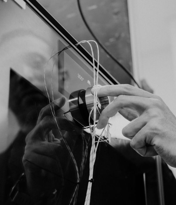 Reflection of a worker in Lipsheim testing the Gaggenau Expressive series oven control ring