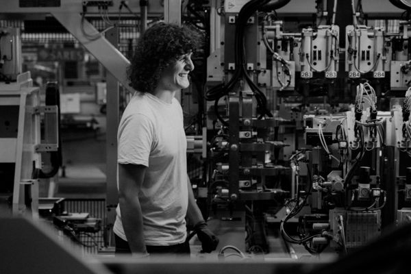 Arthur Desreumaux smiling as he walks between equipment in the Lipsheim factory