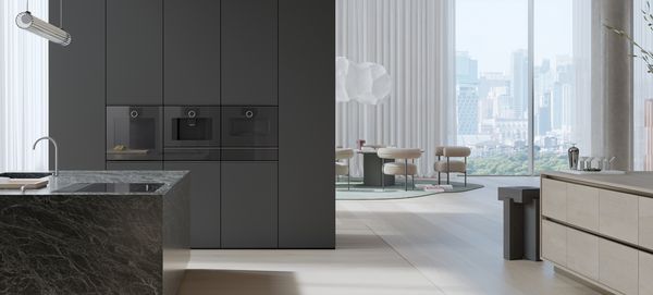 View into an open plan luxury kitchen fitted with Gaggenau Minimalistic series appliances