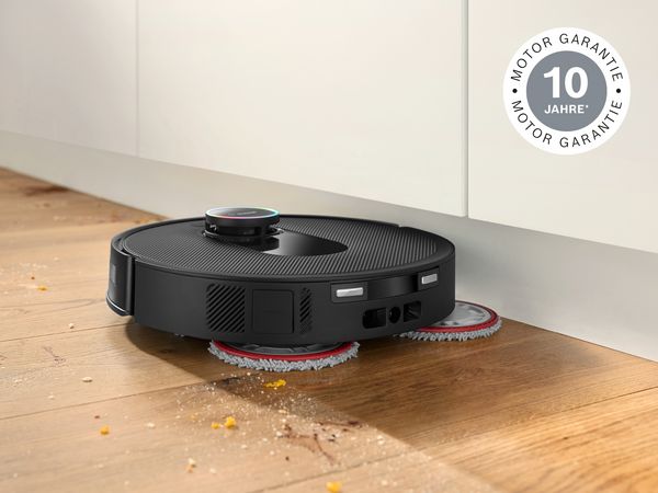 Der Bosch Spotless Saugroboter reinigt einen verschmutzten Holzfußboden.