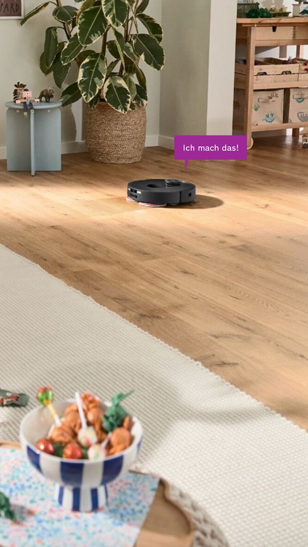 Spotless in einem modernen Wohnzimmer, Sprechblase: "Alles bereit! Rückkehr zu meiner Trocken-Nass-Service-Station." 