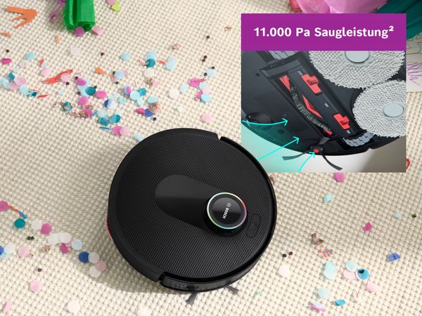 Spotless auf einem weißen Teppich, der einen Weg durch Konfetti freimacht und seine Saugkraft demonstriert.