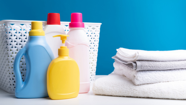 A collection of laundry essentials, including bottles of liquid laundry detergent and fabric softener in various colors