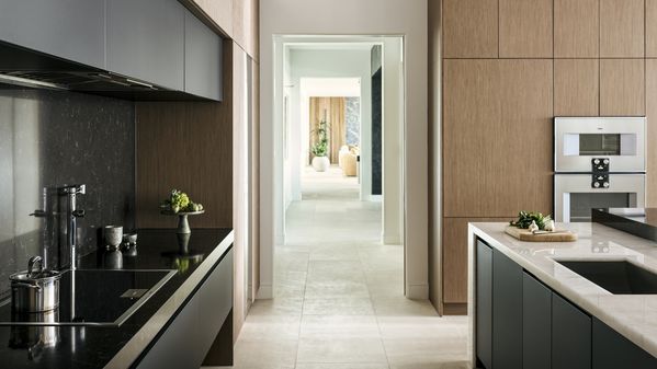A view down a corridor showing the kitchen fitted with Gaggenau appliances and subsequent entertaining rooms