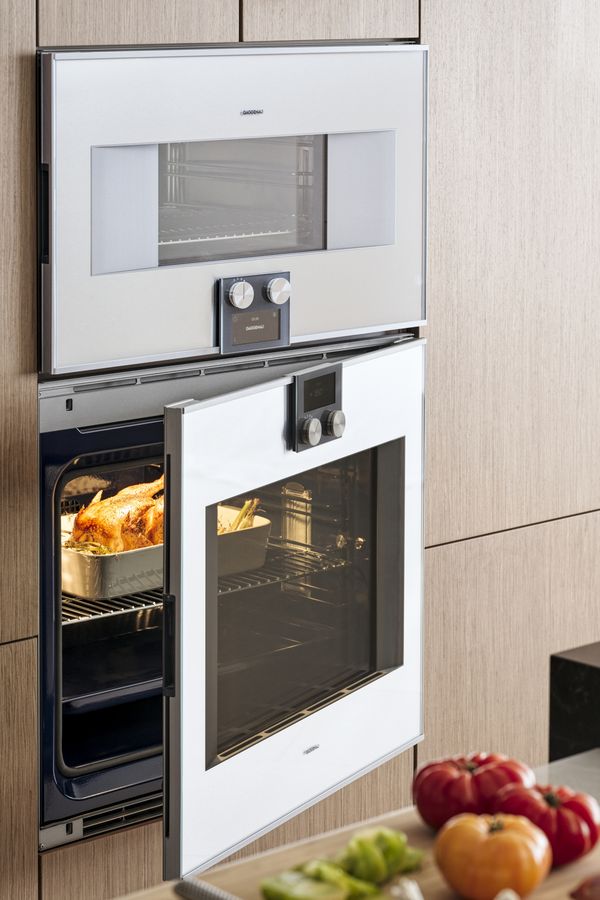 A 30 inch Gaggenau steam oven and a 30 inch convection oven containing a roast chicken
