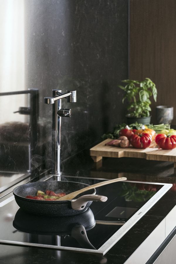 A Gaggenau full surface induction cooktop being used to prepare a meal
