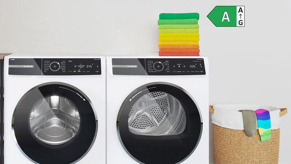 Waschmaschine und Trockner mit Energieeffizienzklasse, Wäschekorb und farbcodierter Energieeffizienzskala.