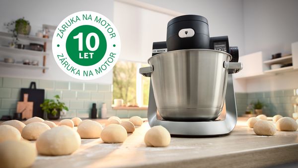Obrázek zachycuje kuchyňský robot Serie 6 na kuchyňské lince vedle množství těsta a loga 10 let záruky.