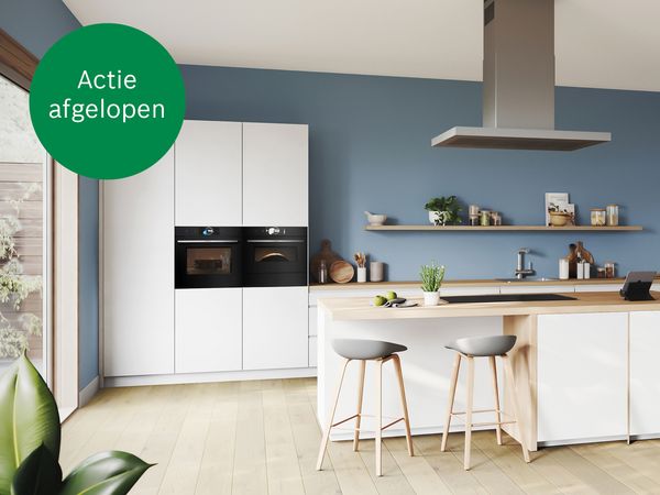 Witte keuken tegen blauwe muur met houten accenten en Bosch keukenapparatuur     