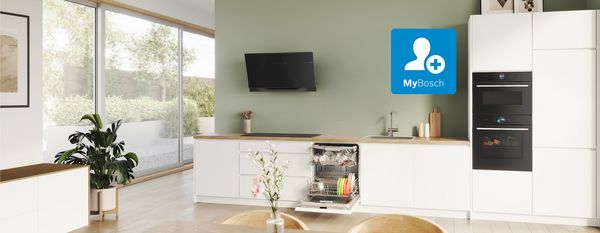 Tea and smartphone on a wooden table in the living room with kitchen in the background.