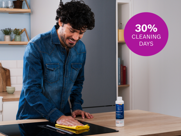 Mand rengør en kogeplade med Bosch kogepladerenser. Øverst på billedet er et logo, hvor der står 30 % rabat Cleaning Days.