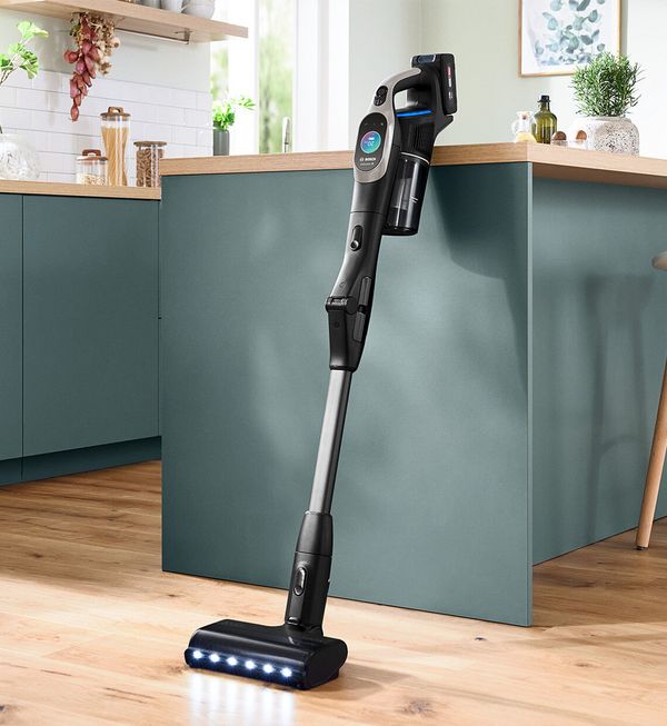 Woman vacuuming up confetti from a high-pile rug with the Athlet.