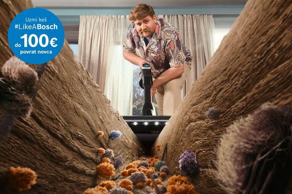 Osoba koristi usisivač u svijetloj sobi, okružena čistim tepihom i vidljivim česticama prašine i alergena